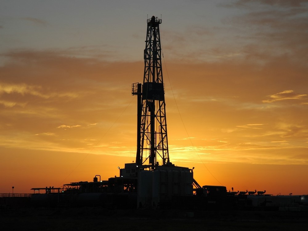 Sunrise behind an oil rig.